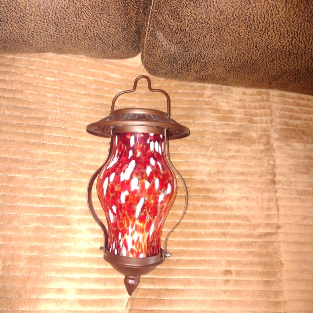 Metal and blown glass hanging votive candle holder.